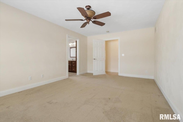 empty room featuring a ceiling fan, light colored carpet, and baseboards