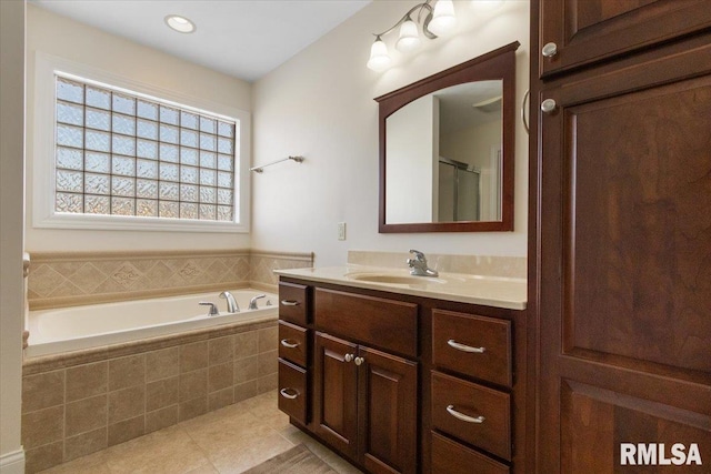 full bath featuring tile patterned flooring, a garden tub, and vanity