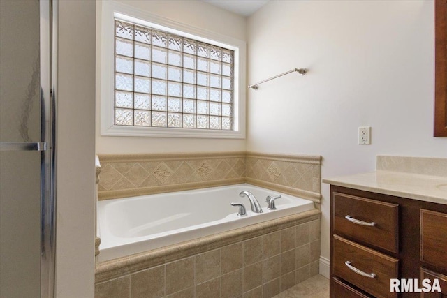 bathroom with a garden tub and vanity