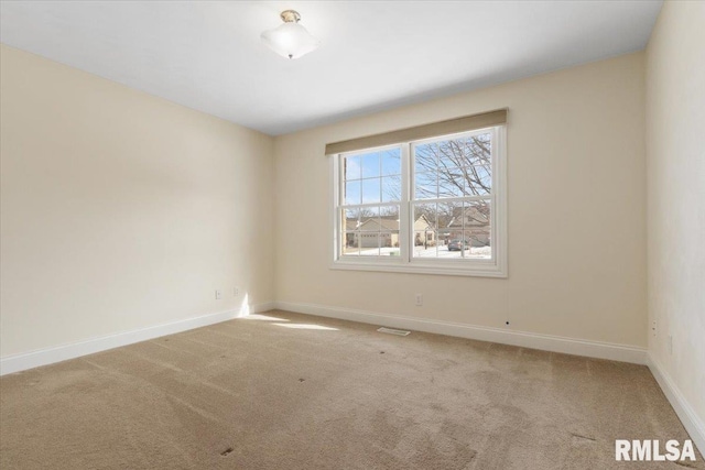 carpeted spare room featuring visible vents and baseboards