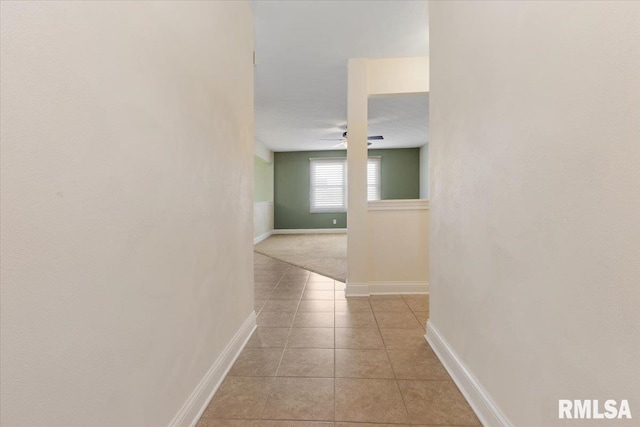 hallway featuring light tile patterned floors and baseboards