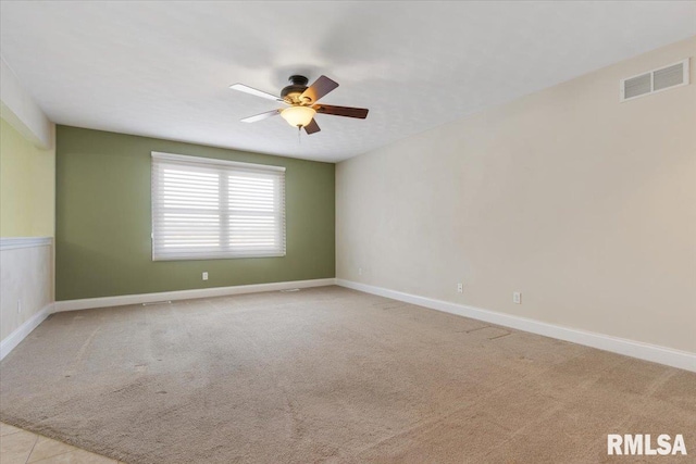 empty room featuring light carpet, baseboards, visible vents, and a ceiling fan