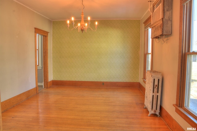 644 S Randolph St, Macomb, IL 61455 - spare room featuring ornamental molding, light wood finished floors, radiator heating unit, and wallpapered walls