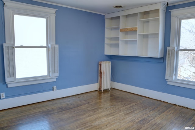 644 S Randolph St, Macomb, IL 61455 - empty room featuring ornamental molding, radiator, baseboards, and wood finished floors