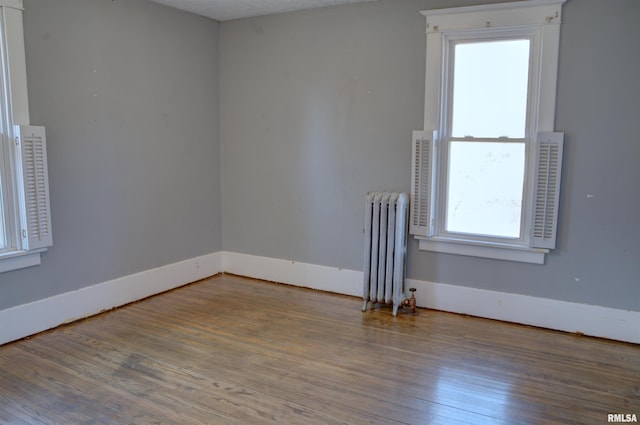 644 S Randolph St, Macomb, IL 61455 - spare room featuring radiator, baseboards, and wood finished floors
