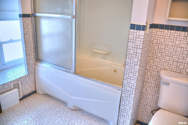 644 S Randolph St, Macomb, IL 61455 - bathroom with washtub / shower combination, toilet, tile walls, and tile patterned floors