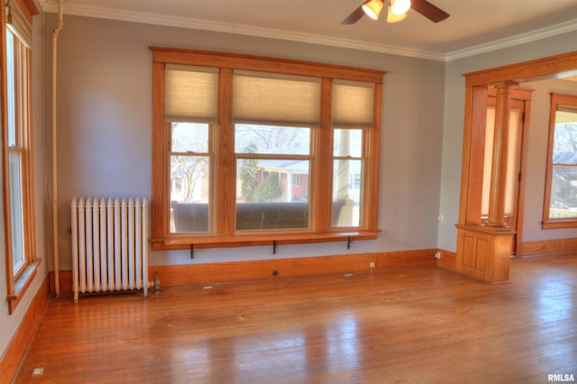 644 S Randolph St, Macomb, IL 61455 - spare room featuring ceiling fan, crown molding, wood finished floors, radiator, and ornate columns