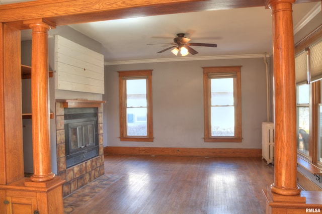 644 S Randolph St, Macomb, IL 61455 - unfurnished living room with dark wood-type flooring, a fireplace with flush hearth, radiator heating unit, decorative columns, and crown molding