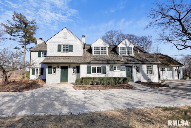 view of front of home with a chimney and brick siding