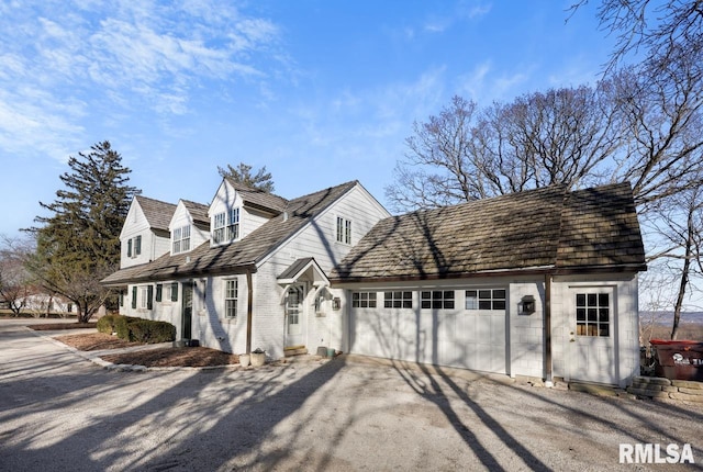 view of home's exterior with aphalt driveway, an attached garage, and brick siding