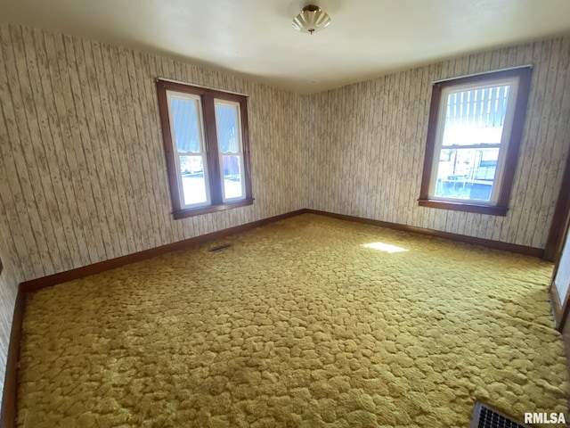 unfurnished room with visible vents, baseboards, and carpet flooring