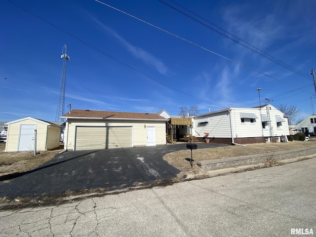 view of front of home with a garage and an outdoor structure