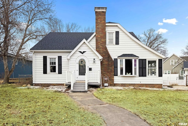 bungalow-style house featuring fence, a chimney, and a front lawn