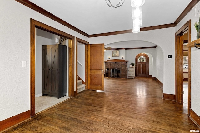 interior space with ornamental molding, wood finished floors, and baseboards