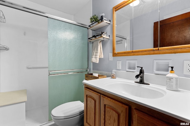 bathroom featuring toilet, a stall shower, and vanity