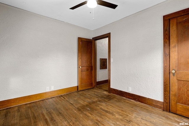 empty room featuring ceiling fan, baseboards, and wood finished floors