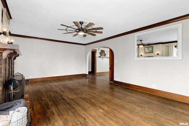 unfurnished living room with baseboards, arched walkways, a ceiling fan, dark wood-style floors, and crown molding