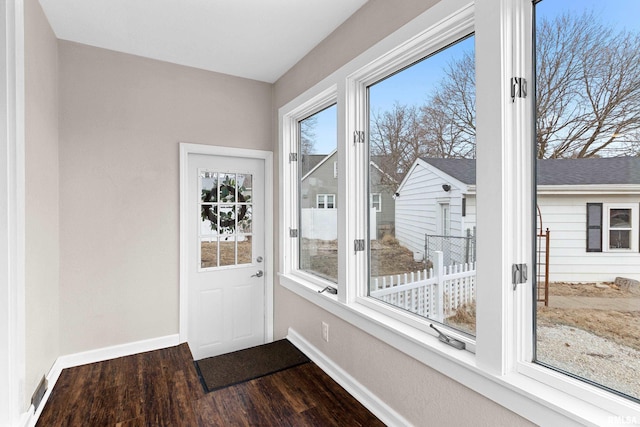 doorway to outside with dark wood-style floors and baseboards