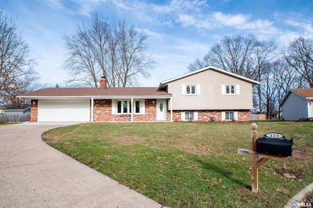 tri-level home with brick siding, driveway, an attached garage, and a front yard