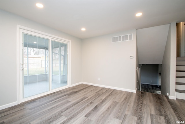 unfurnished room with stairs, visible vents, wood finished floors, and recessed lighting