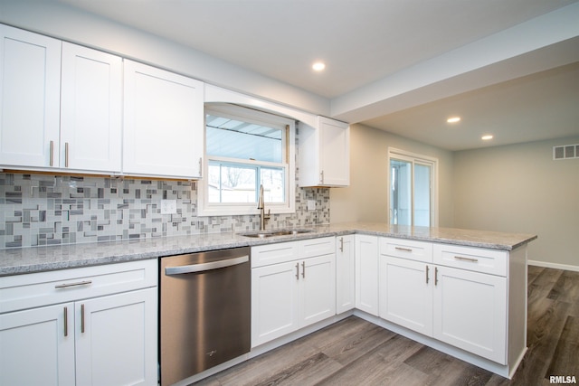 kitchen with a peninsula, a sink, visible vents, white cabinetry, and dishwasher