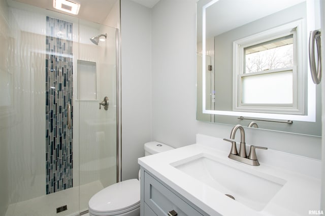 bathroom with visible vents, vanity, a shower stall, and toilet