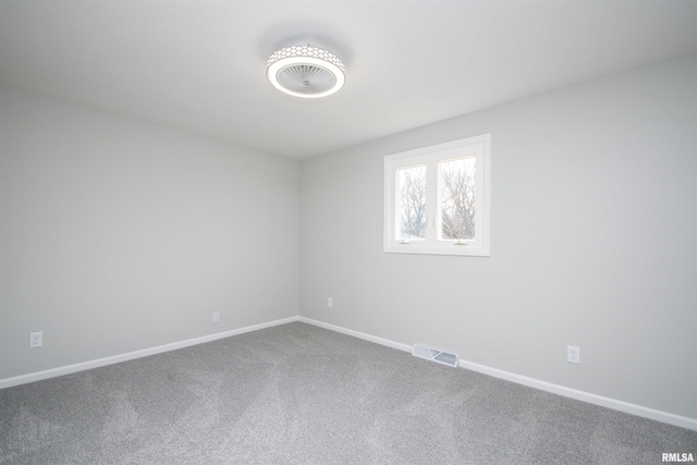 carpeted empty room featuring visible vents and baseboards