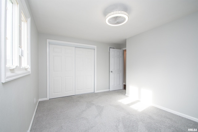 unfurnished bedroom featuring carpet, a closet, and baseboards