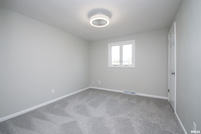 unfurnished room featuring carpet flooring, visible vents, and baseboards