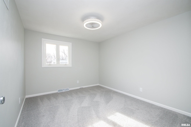 carpeted empty room with visible vents and baseboards