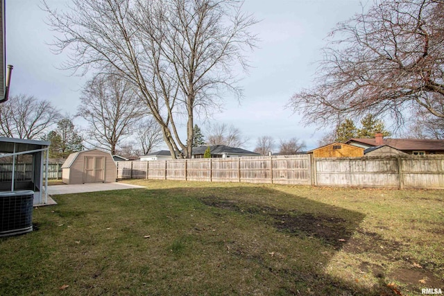 view of yard featuring an outbuilding, a patio area, central AC, a shed, and a fenced backyard