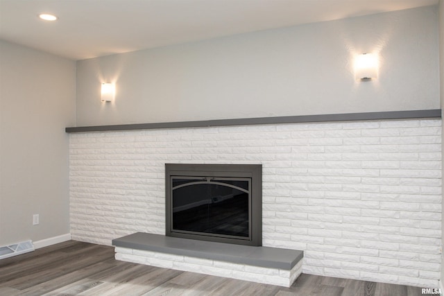 room details with recessed lighting, a fireplace, wood finished floors, visible vents, and baseboards