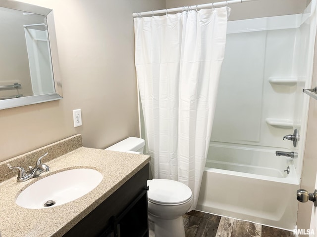 full bath with shower / bath combo, vanity, toilet, and wood finished floors