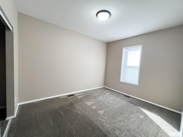 carpeted empty room with visible vents and baseboards