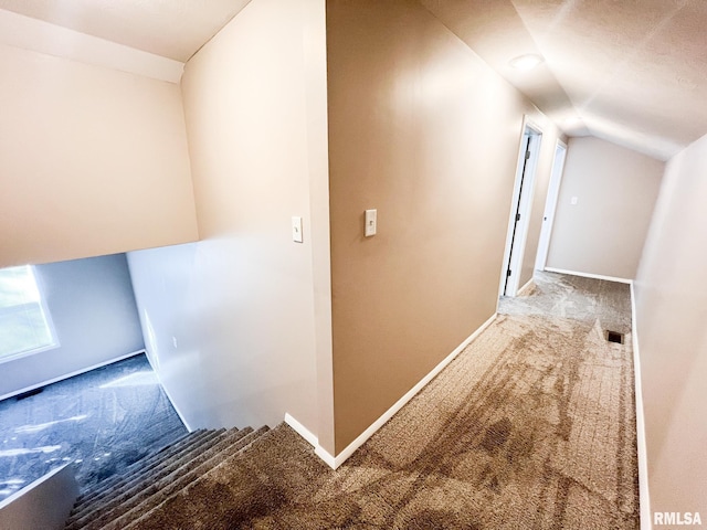 corridor with vaulted ceiling, carpet flooring, and baseboards