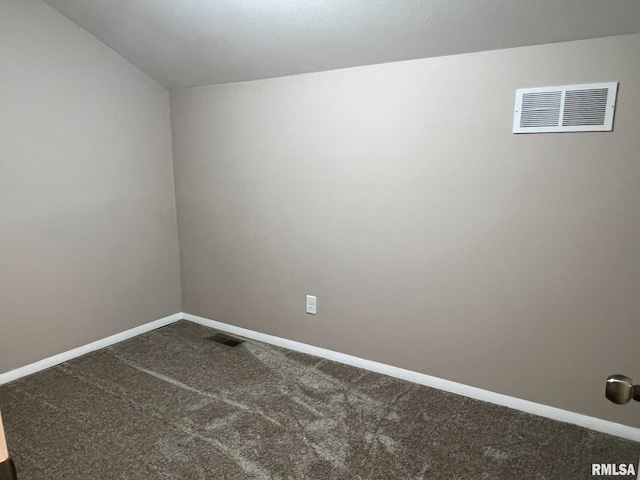 spare room with baseboards, visible vents, and dark colored carpet