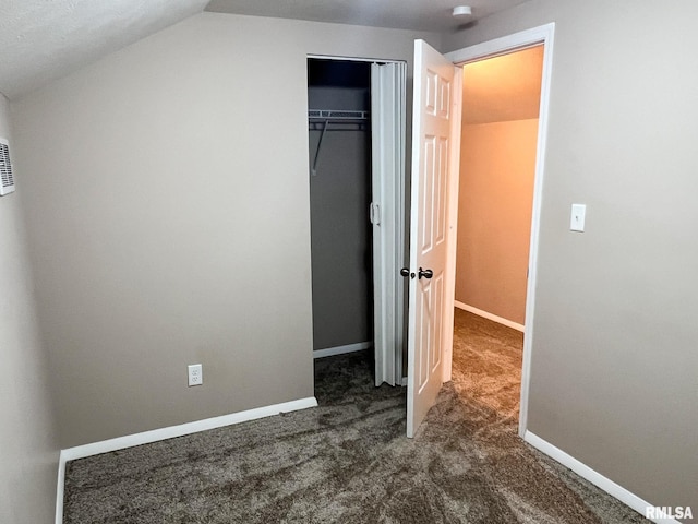 unfurnished bedroom featuring vaulted ceiling, carpet floors, a closet, and baseboards