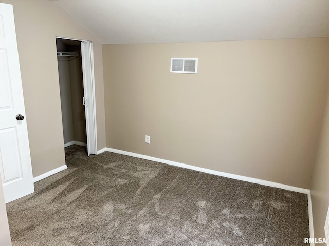 unfurnished bedroom featuring carpet flooring, visible vents, baseboards, vaulted ceiling, and a closet