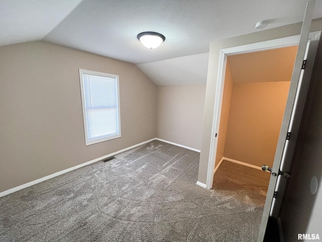 additional living space with lofted ceiling, carpet, visible vents, and baseboards