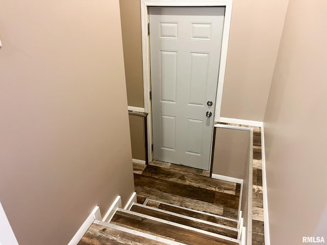 stairs featuring baseboards and hardwood / wood-style floors