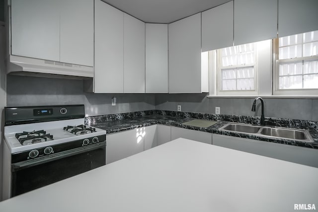 kitchen featuring under cabinet range hood, a sink, white cabinetry, modern cabinets, and gas range