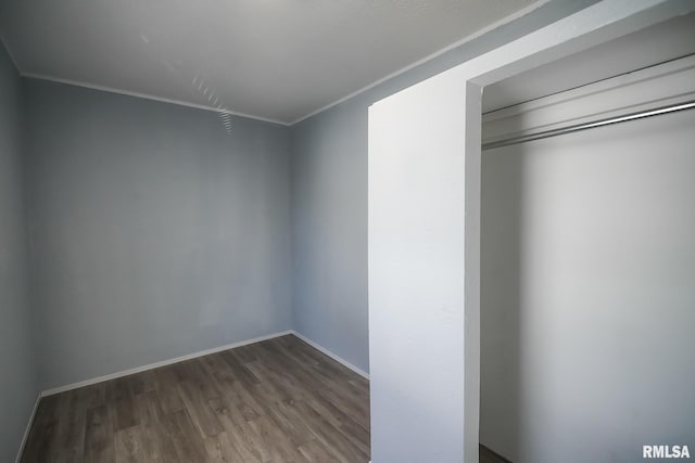 unfurnished bedroom featuring crown molding, dark wood-type flooring, and baseboards