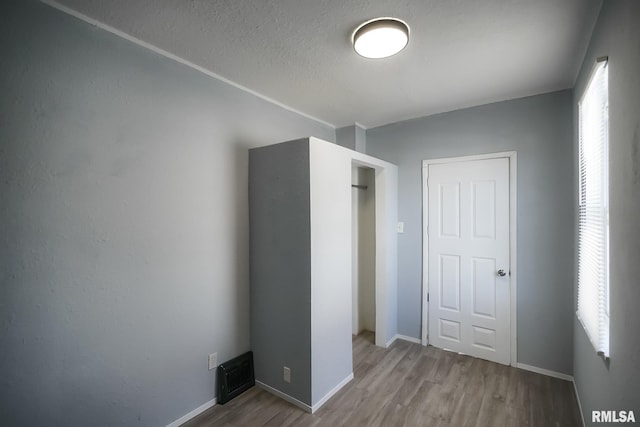 unfurnished bedroom with light wood-style flooring, visible vents, and baseboards