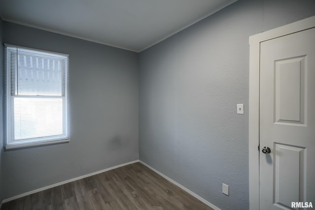 spare room with dark wood finished floors and baseboards