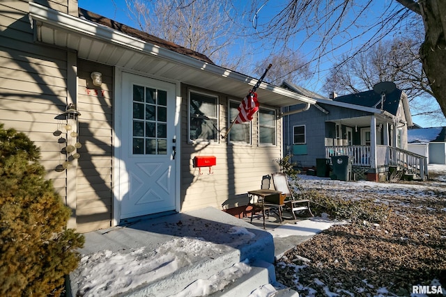 snow covered property entrance featuring a patio