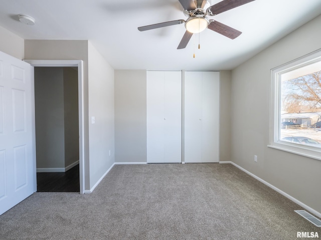 unfurnished bedroom with baseboards, visible vents, ceiling fan, and carpet flooring