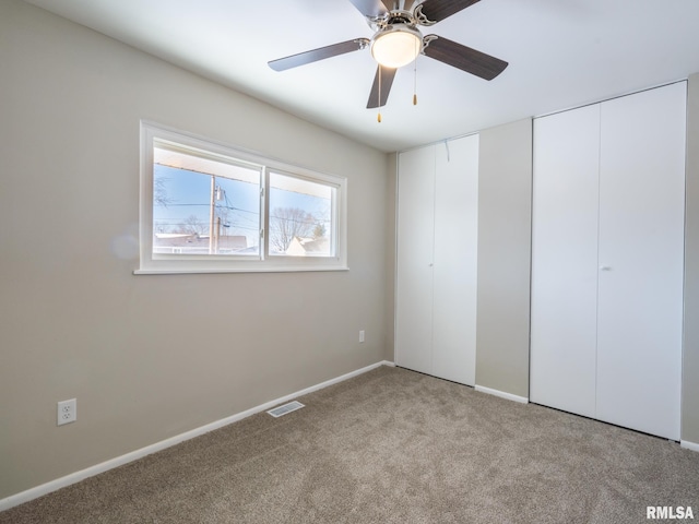 unfurnished bedroom featuring light carpet, ceiling fan, visible vents, and baseboards