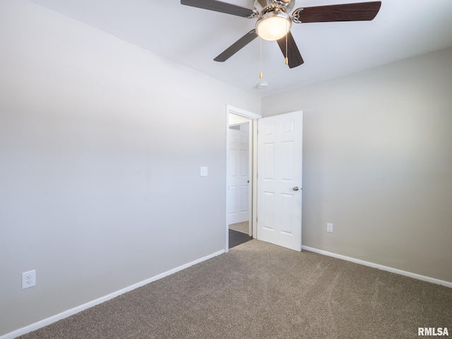 carpeted spare room with ceiling fan and baseboards