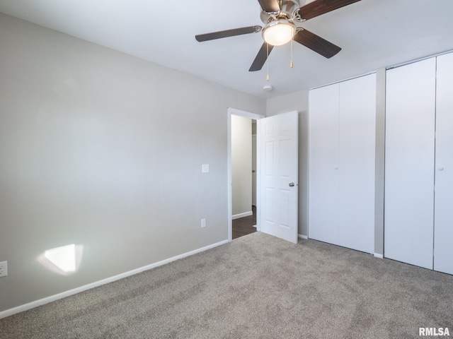 unfurnished bedroom featuring baseboards, ceiling fan, carpet flooring, and multiple closets