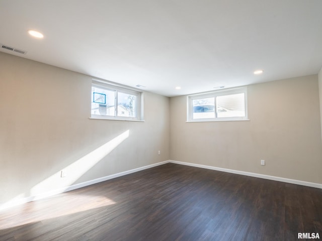 basement with dark wood-style floors, recessed lighting, visible vents, and baseboards